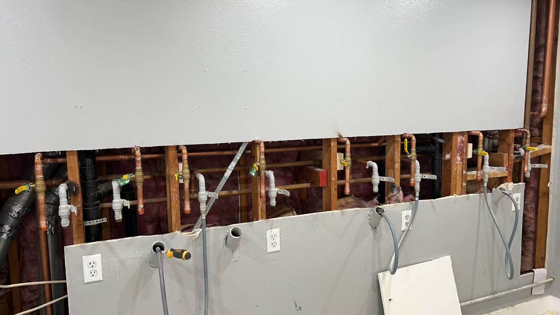 Laundry room pipework before wall restoration